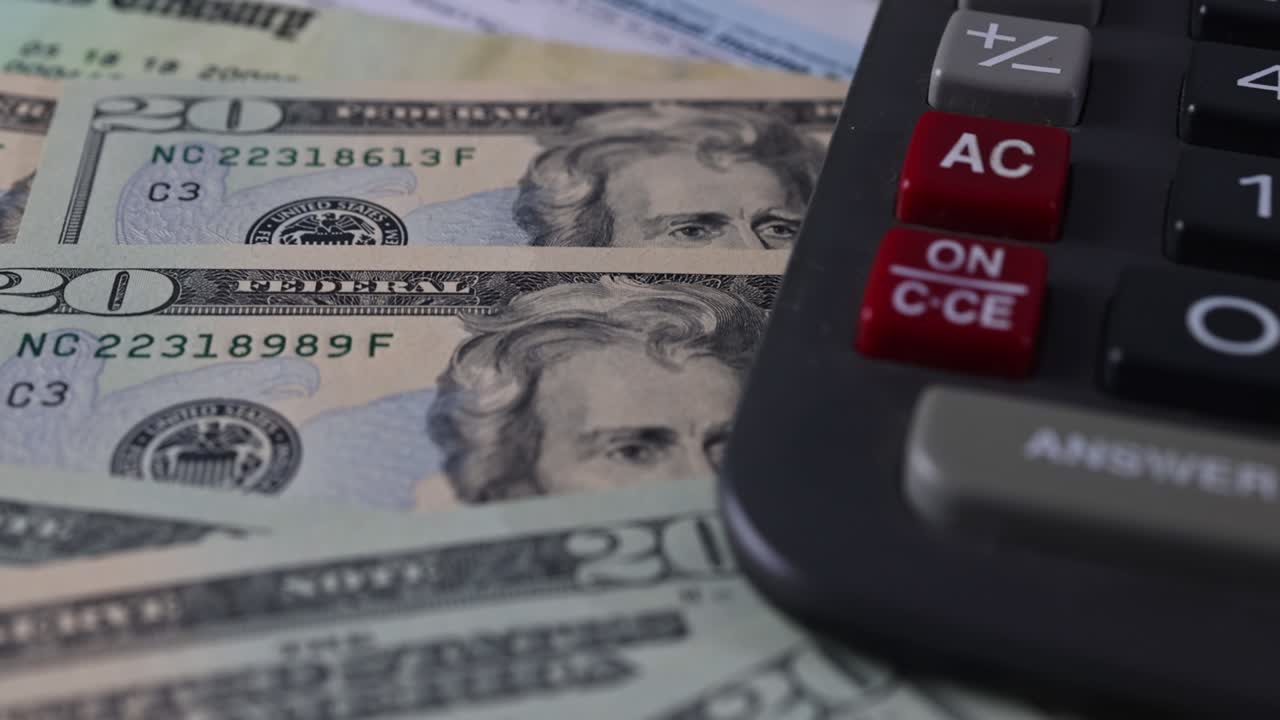 formulario de impuestos 1040 con cheque de reembolso y moneda billetes de dólar estadounidense de primer plano