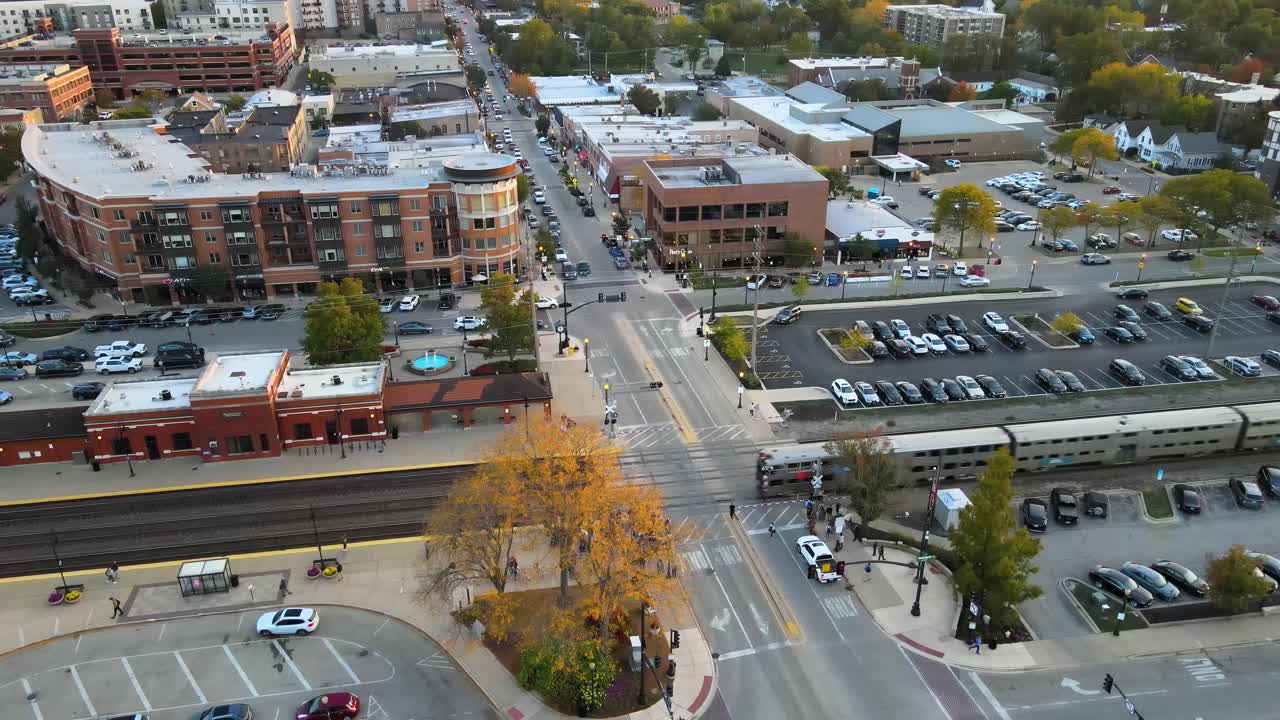 Commuter train crossing through Downers Grove Illinois train station at sunset. Crane Up Sunset S