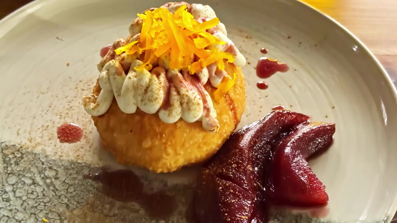Uno zoom cinematografico su un dessert italiano splendidamente impiattato con pasta dorata e pere sciroppate.