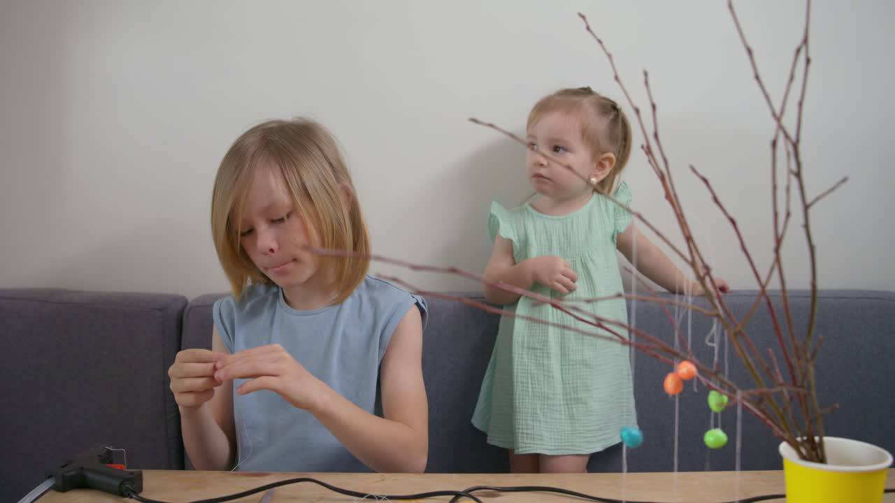 Two Young Girls Crafting Easter Decorations at Home