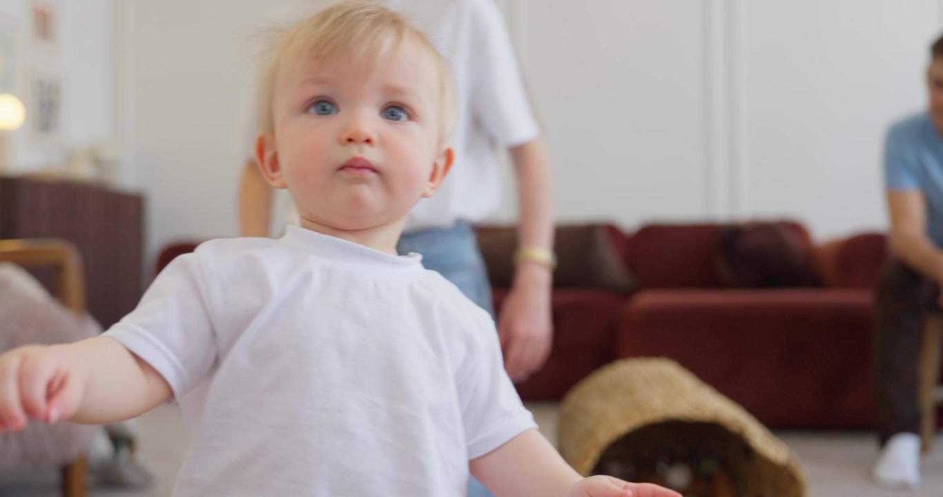 Bebé feliz aprendiendo a caminar con el apoyo de su madre en casa