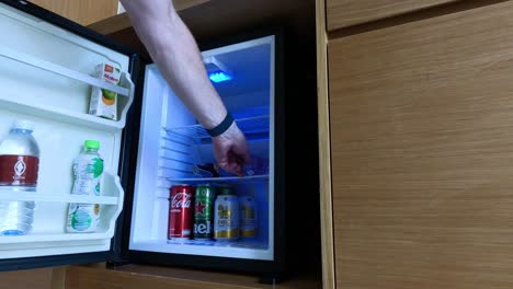 hand retrieving a drink from a fridge