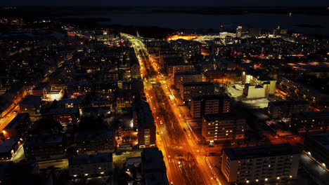 Aerial-view-tilting-over-the-quiet-E12-esplanade,-night-in-Vaasa,-Finland