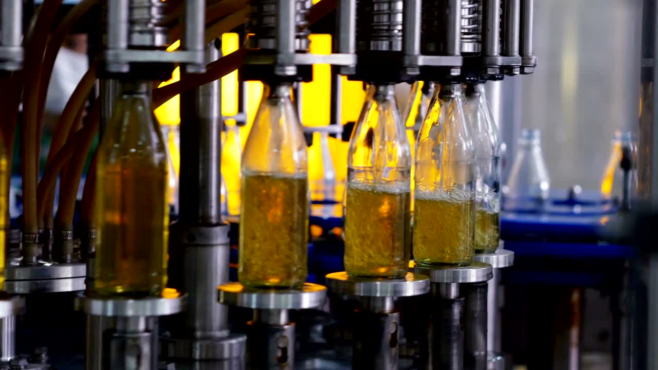 Linha de produção automática para enchimento de água em garrafa de vidro. Engarrafamento de bebida de ervas em garrafas de vidro. Produção de água potável e bebidas.