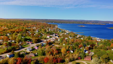aerial drone shot over the coastline of oak island, nova scotia, canada.
high view of the sea, autumn colorful trees foliage. picturesque landscape. fall vibrant colors.
