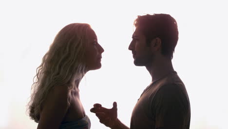 una pareja discutiendo contra la luz del sol.