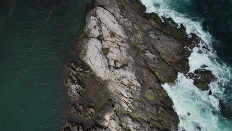 white foamy waves crash on the rocks of the narragansett bay shoreline