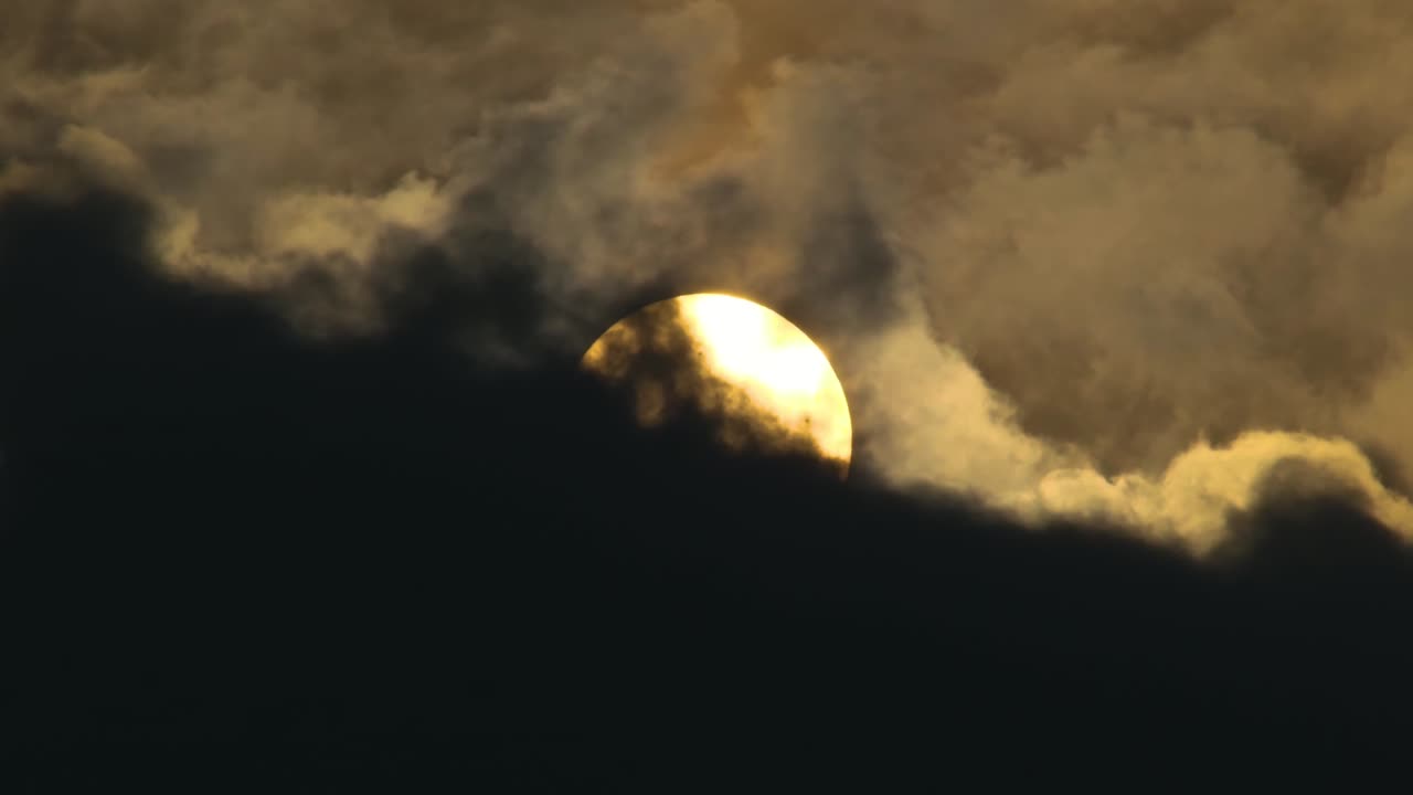 el sol asomando a través de las nubes oscuras