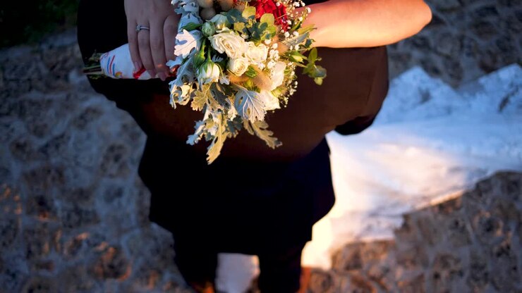 Brudepar holder hinanden i armene med smuk blomsterbuket, ovenfra-optagelse