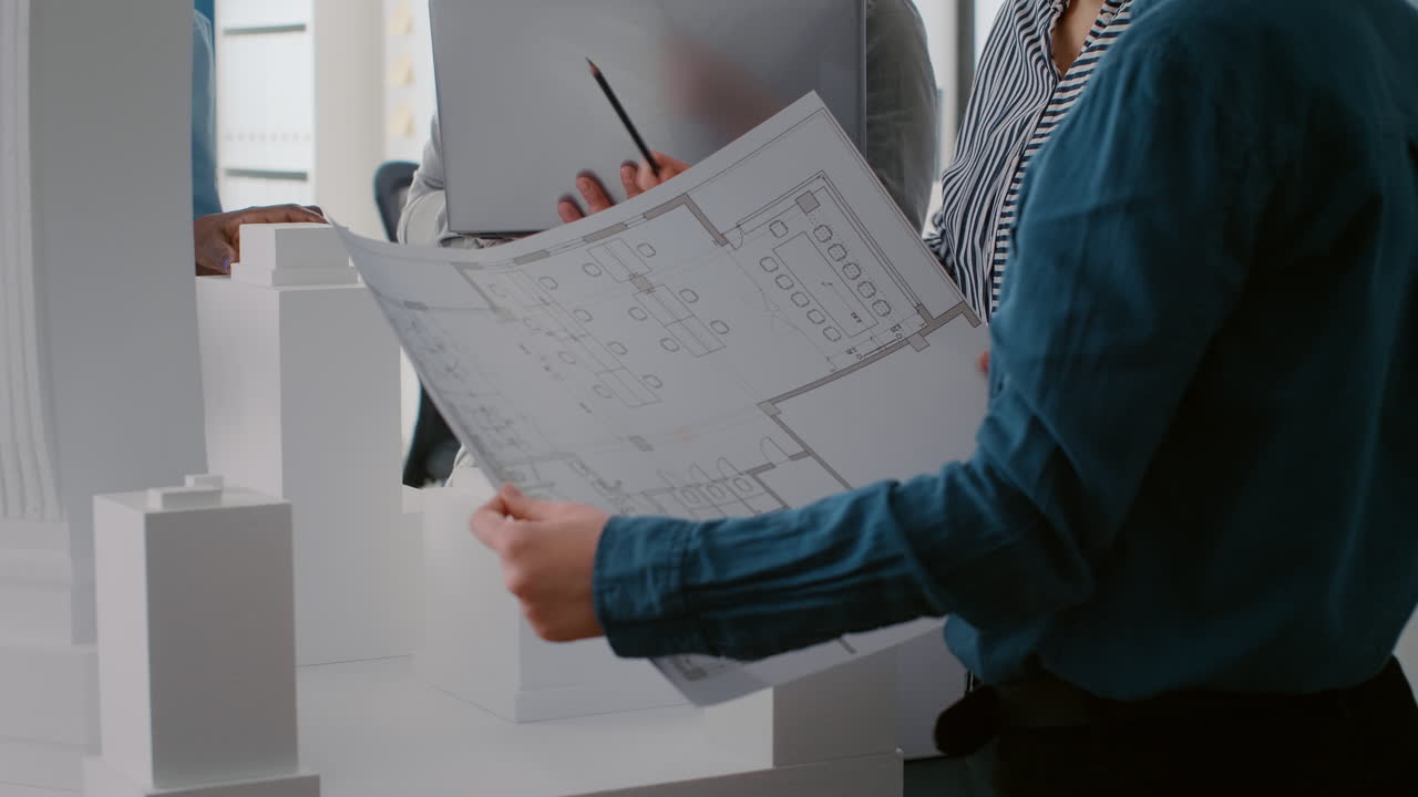 Architects Collaborating on Blueprint in Office