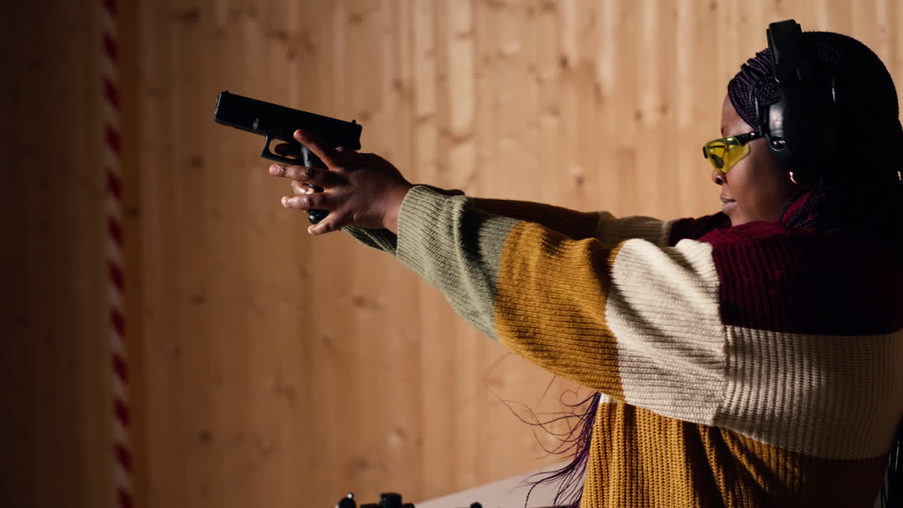 mujer alegre en el campo de tiro probando un nuevo modelo de arma
