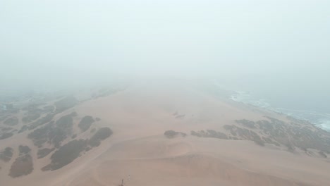 Aerial-Dolly-Aus-Orangefarbenen-Sanddünen-In-Einem-Hügel-Nahe-Dem-Meer-An-Einem-Bewölkten,-Nebligen-Tag-In-Concon,-Chile