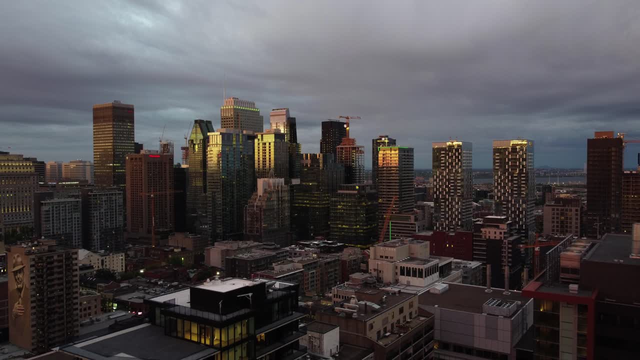 un dron que se acerca a los rascacielos en montreal, nubes grises