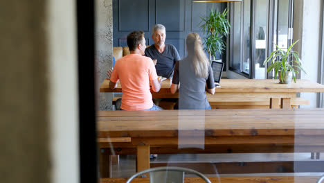 Executives-discussing-over-laptop-in-office-cafeteria-4k