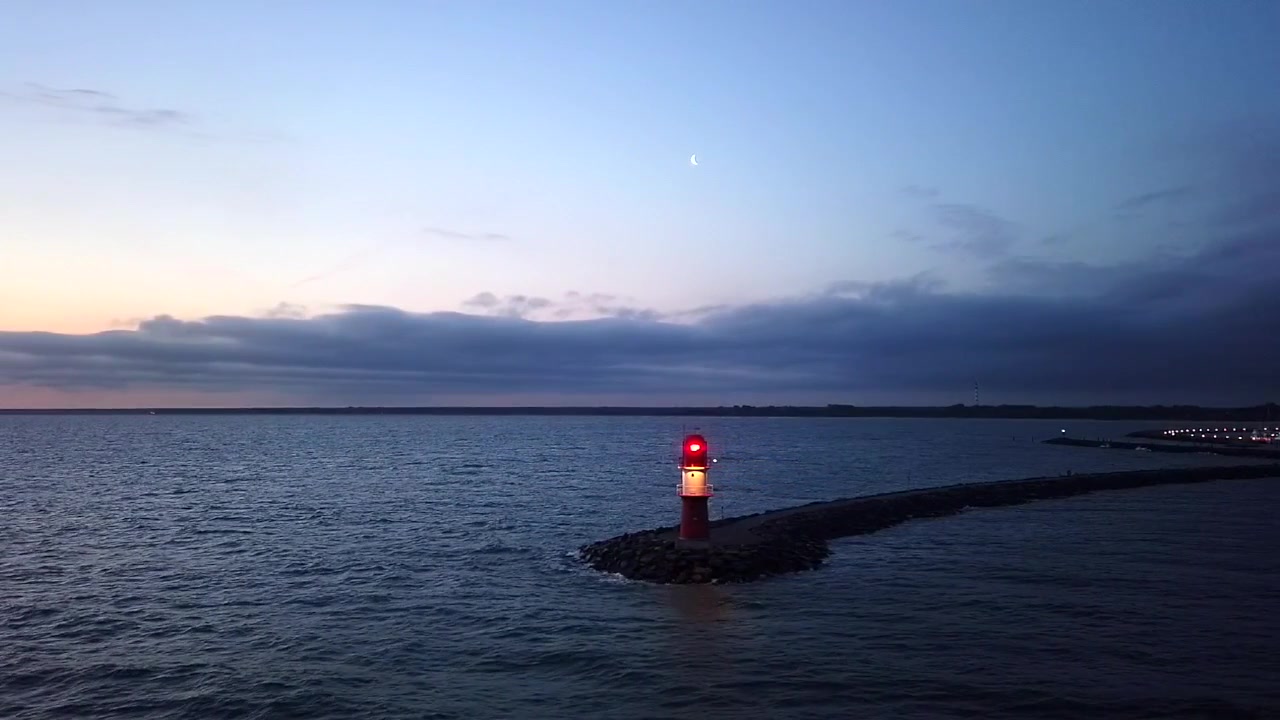 Passando lentamente davanti a un faro lampeggiante, di prima mattina.
