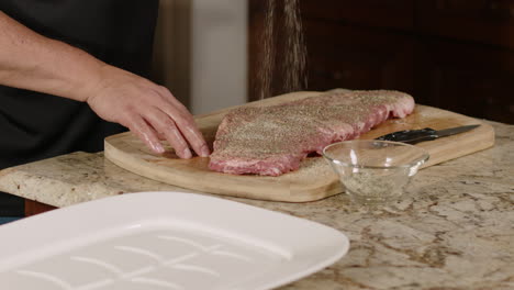 raw pork ribs being being seasoned with spices in slow motion