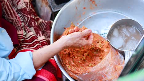 hand shaping fish cakes at floating market