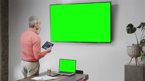 hombre de negocios caucásico en videollamada con pantalla verde pantalla de televisión
