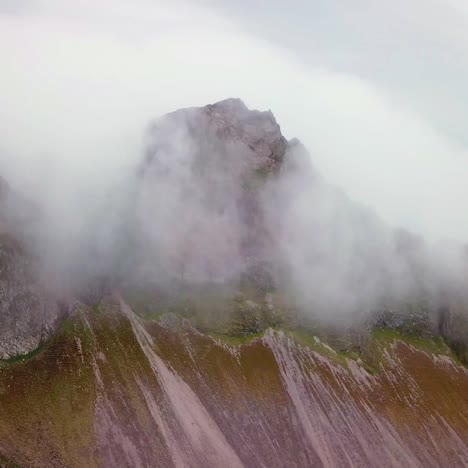 Toma-Aérea-De-Notables-Hermosos-Fiordos-En-Islandia-Con-Nubes-Y-Niebla-Rodando-Sobre-La-Parte-Superior