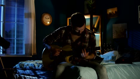 young man playing guitar at night