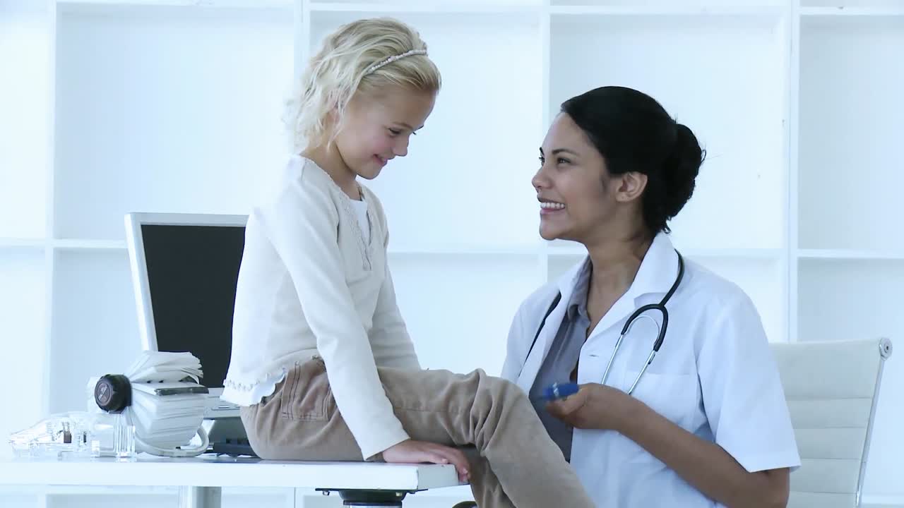 Female doctor checking little girls reflexes