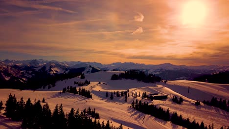 Picturesque-white-mountain-slopes-covered-with-pine-forests-and-skiing-pistes-and-moving-chairlift-in-eavning-Sunset-aerial-view