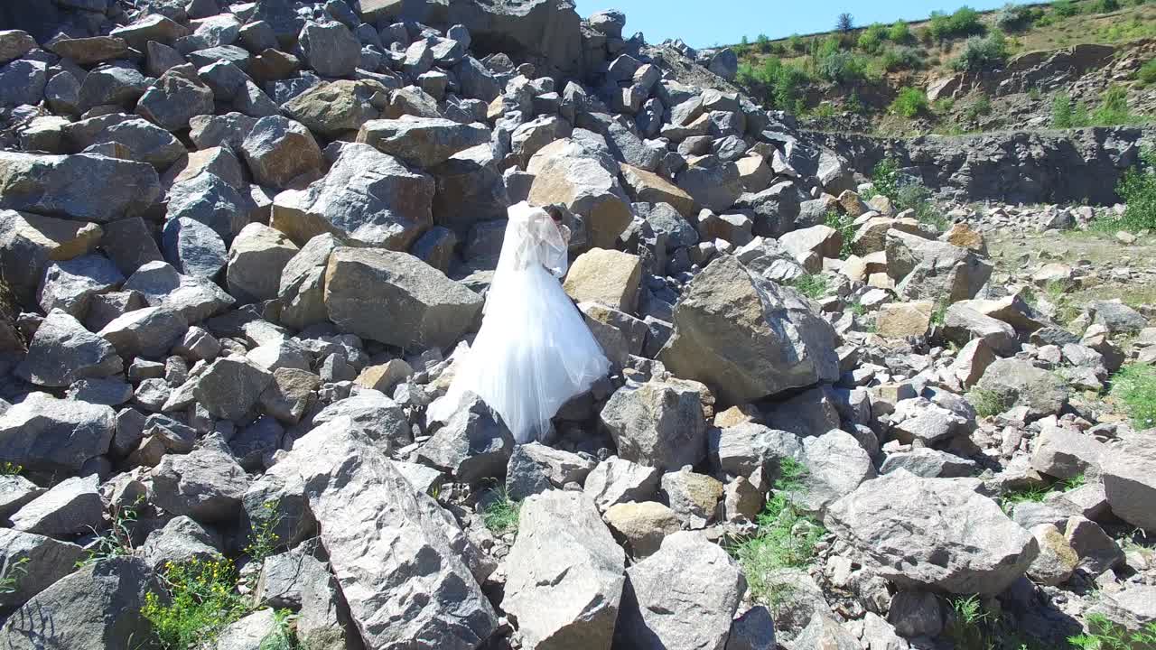 Young Wedding Couple Outdoor. Aerial shot of a loving wedding couple walking on stony landscapes
