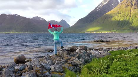 Mujer-Con-Una-Bandera-Ondeante-De-Noruega-En-El-Fondo-De-La-Naturaleza.