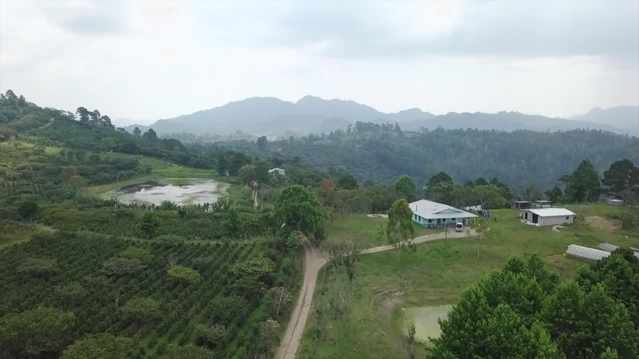 4K uphill road with a valley mountain and landscape with green fields and farming crops