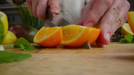 chef cutting oranges for a cocktail