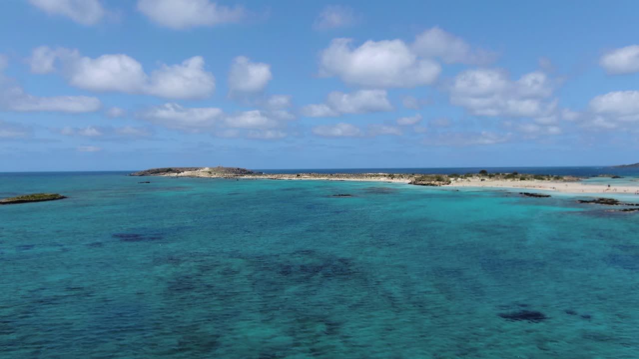 Fly over turquoise green sea of Crete, white sandbank on cloudy day