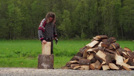 man chopping logs with an ax outdoors - wide