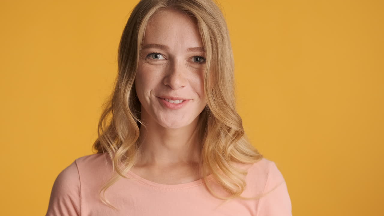 Caucasian woman calmly looking and smiling at camera.