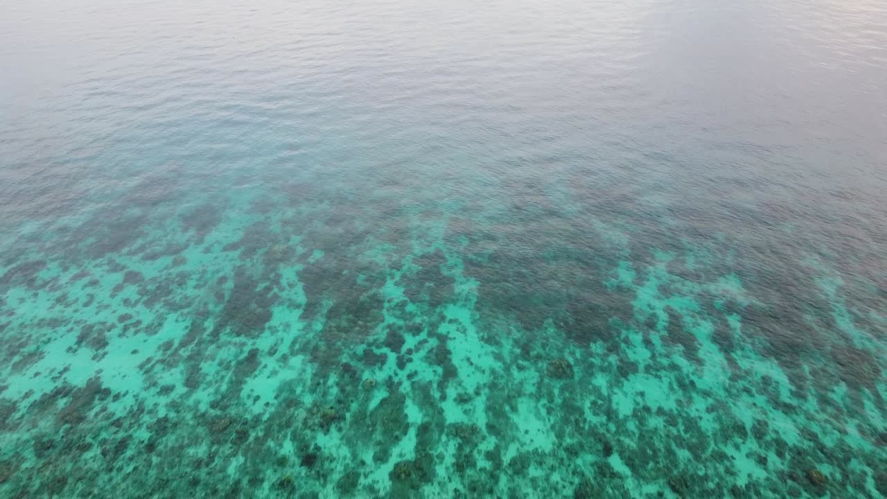 Aerial drone reversing over coral reef environment in turquoise water ocean of Coral Triangle region of Timor-Leste in Southeast Asia