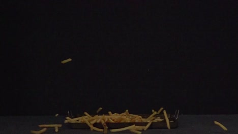 French fries falling in 1000fps at black background