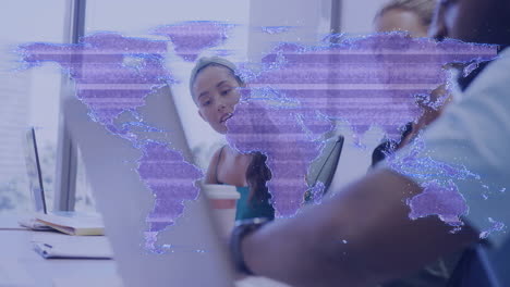 Professional woman reviewing laptop in office, showing business tech with animated data map overlay