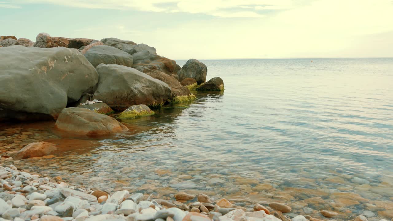 바위 위에 부히는 바다의 물결의 전면 전망. 바다의 큰 돌과 거품이 있는 바위.