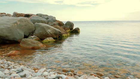 vista frontal de las olas del mar rompiendo en las rocas. roca con las grandes piedras en el mar y olas con espuma.