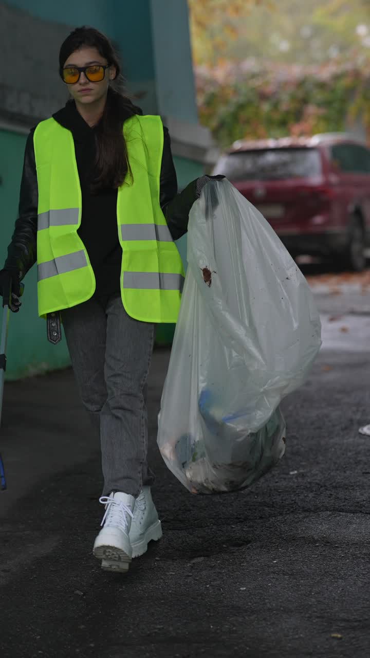 mujer limpiando la basura en una calle de la ciudad