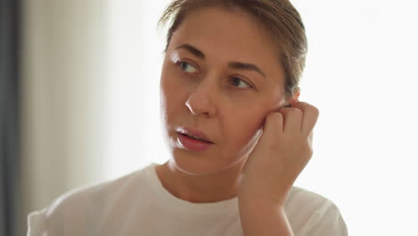 mujer coloca auriculares mientras corre en el interior de primer plano. fit lady emplea auriculares inalámbricos mientras hace ejercicio en un gimnasio privado. estilo de vida de fitness