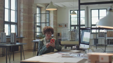 woman using smartphone at desk in modern office