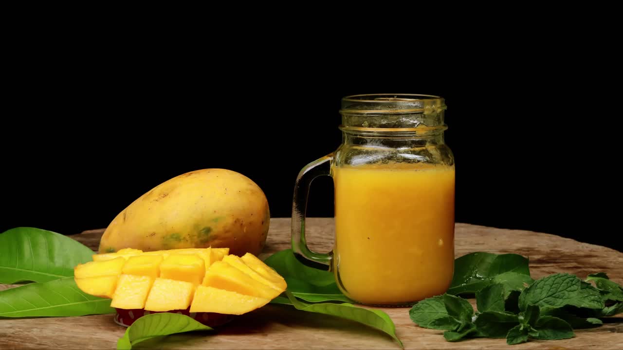 detener el batido de jugo de mango en frasco de vidrio, fondo negro
