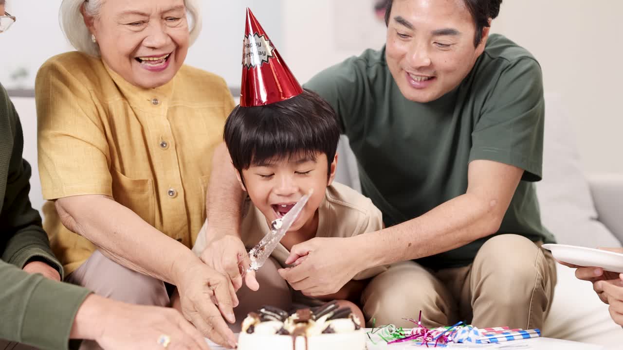 Elderly family and child joyfully cut birthday cake together, celebrating in a warm, festive home