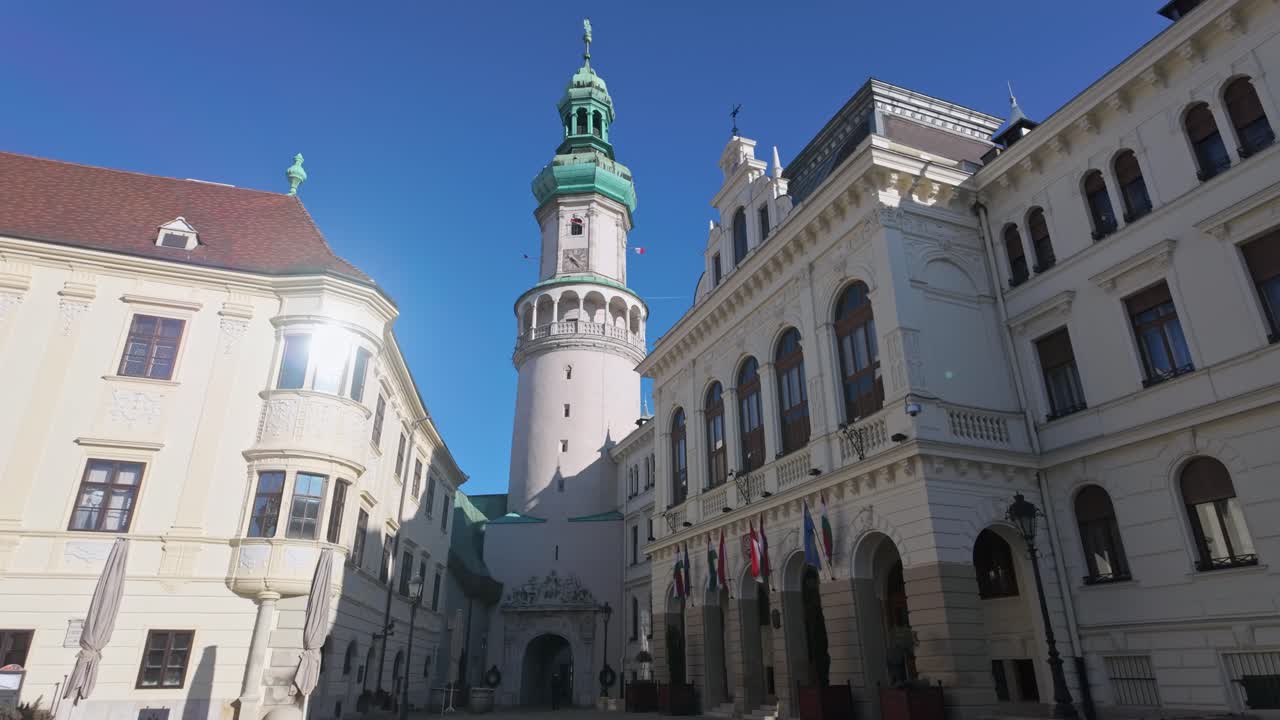 The iconic Fire Tower rises into the blue sky as the tallest building in Sopron, next to the town hall, on a sunny winter day in Hungary.