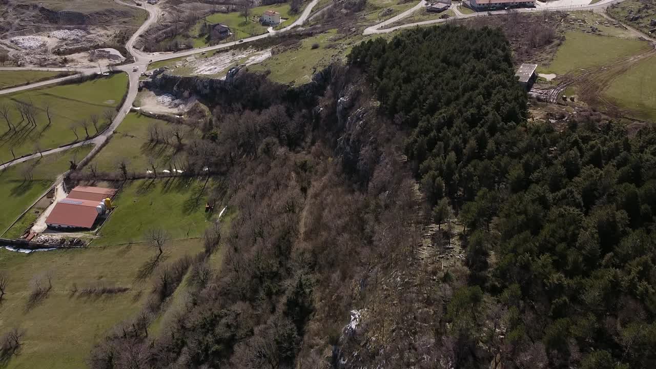 vista aérea sobre caminos rurales y bosques verdes en las montañas rocosas de los apeninos, italia