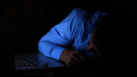 un hombre de negocios durmiendo en su portátil por la noche.