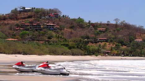 Beach-shot-with-jet-skis-sitting-on-sand