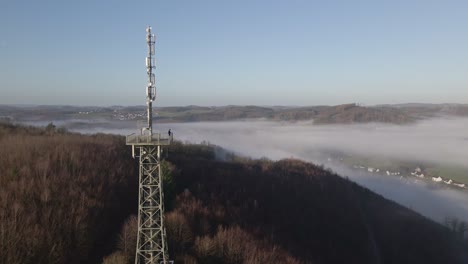 one person standing on top of a steel observation tower taking in the beautiful view at sunrise