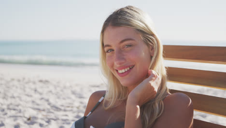caucasian woman sitting on a sunbed on the beach