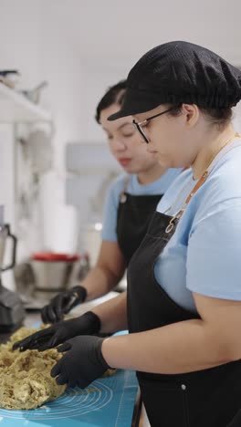 two women preparing food in a kitchen